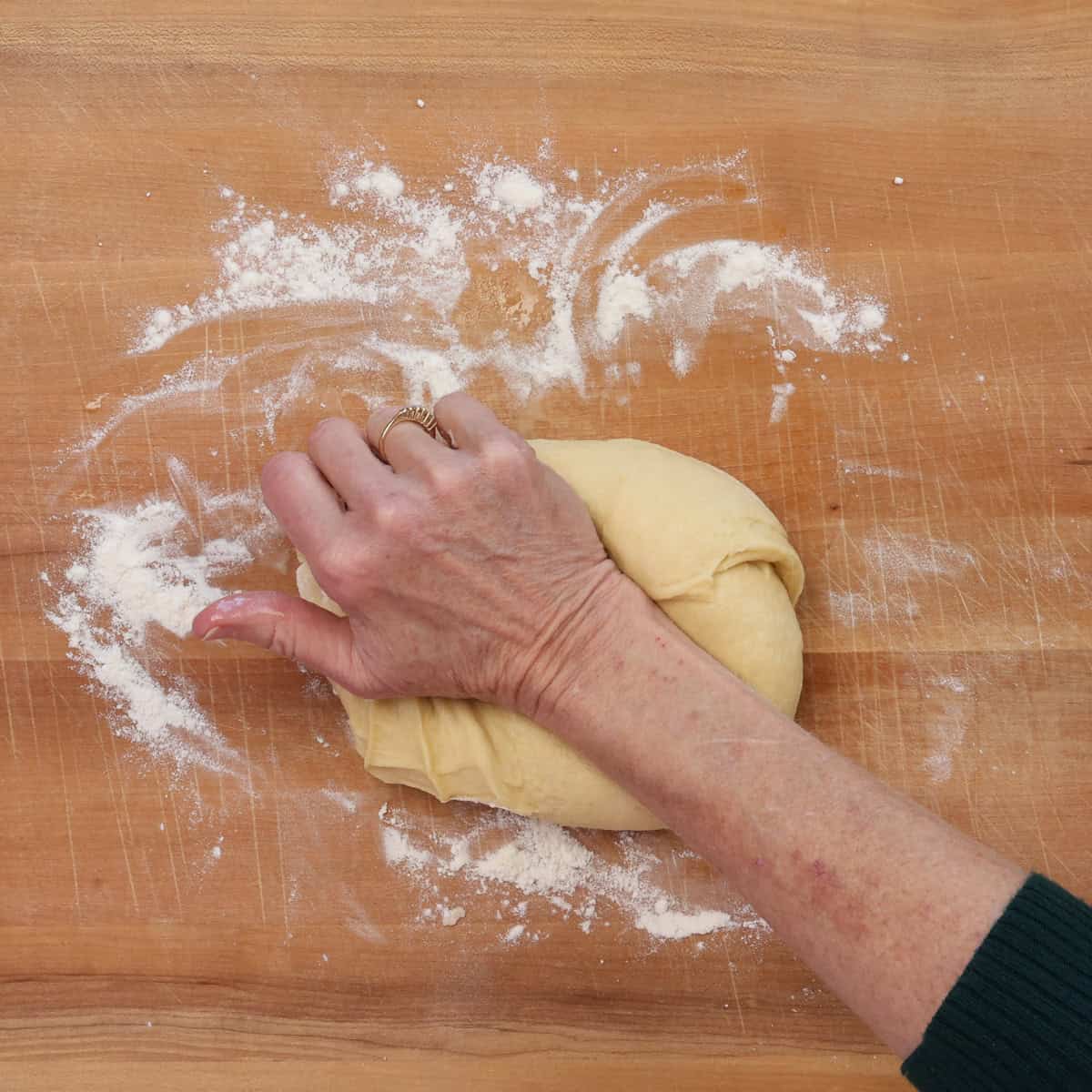 kneading king cake dough on a floured surface.