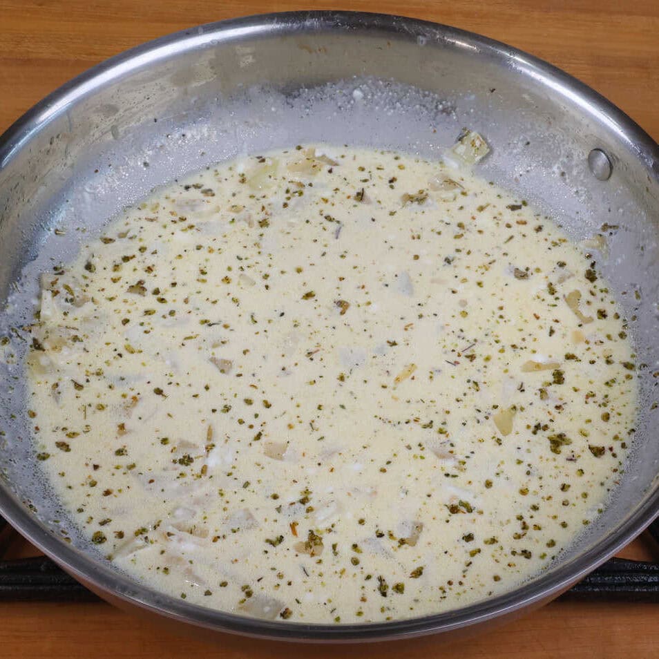 a homemade cream of chicken sauce simmering in a pan.