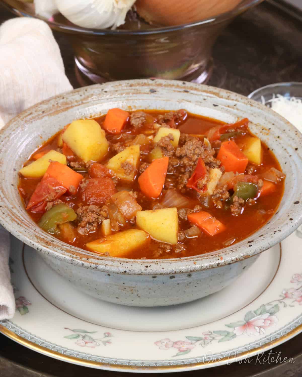 a bowl of hamburgers soup on a silver tray.