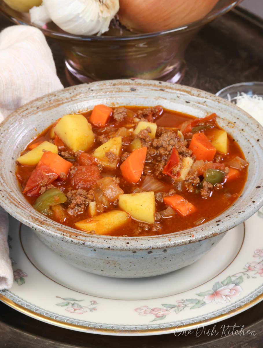 a bowl of hamburgers soup on a silver tray.