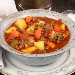 a blue bowl filled with hamburger soup.