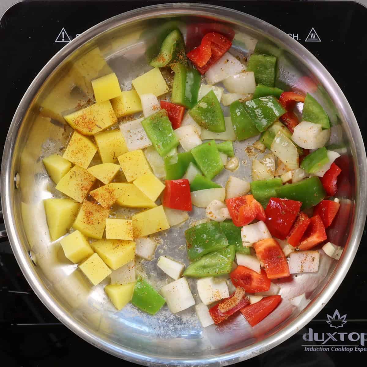 potatoes o'brien cooking in a skillet.