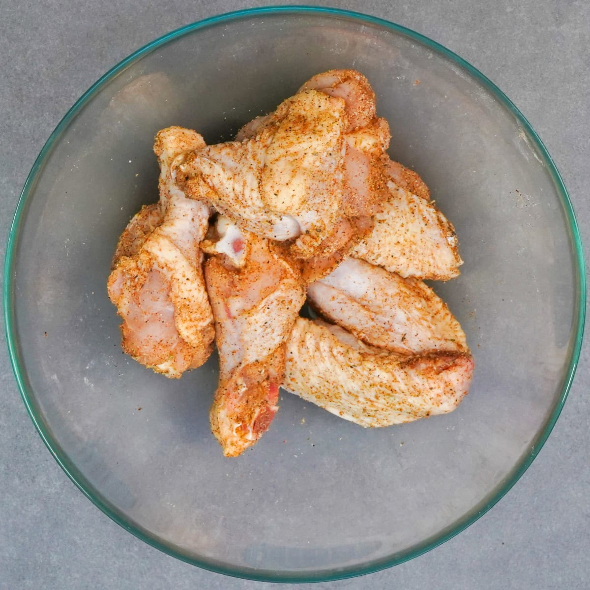 a small batch of seasoned chicken wings in a bowl.