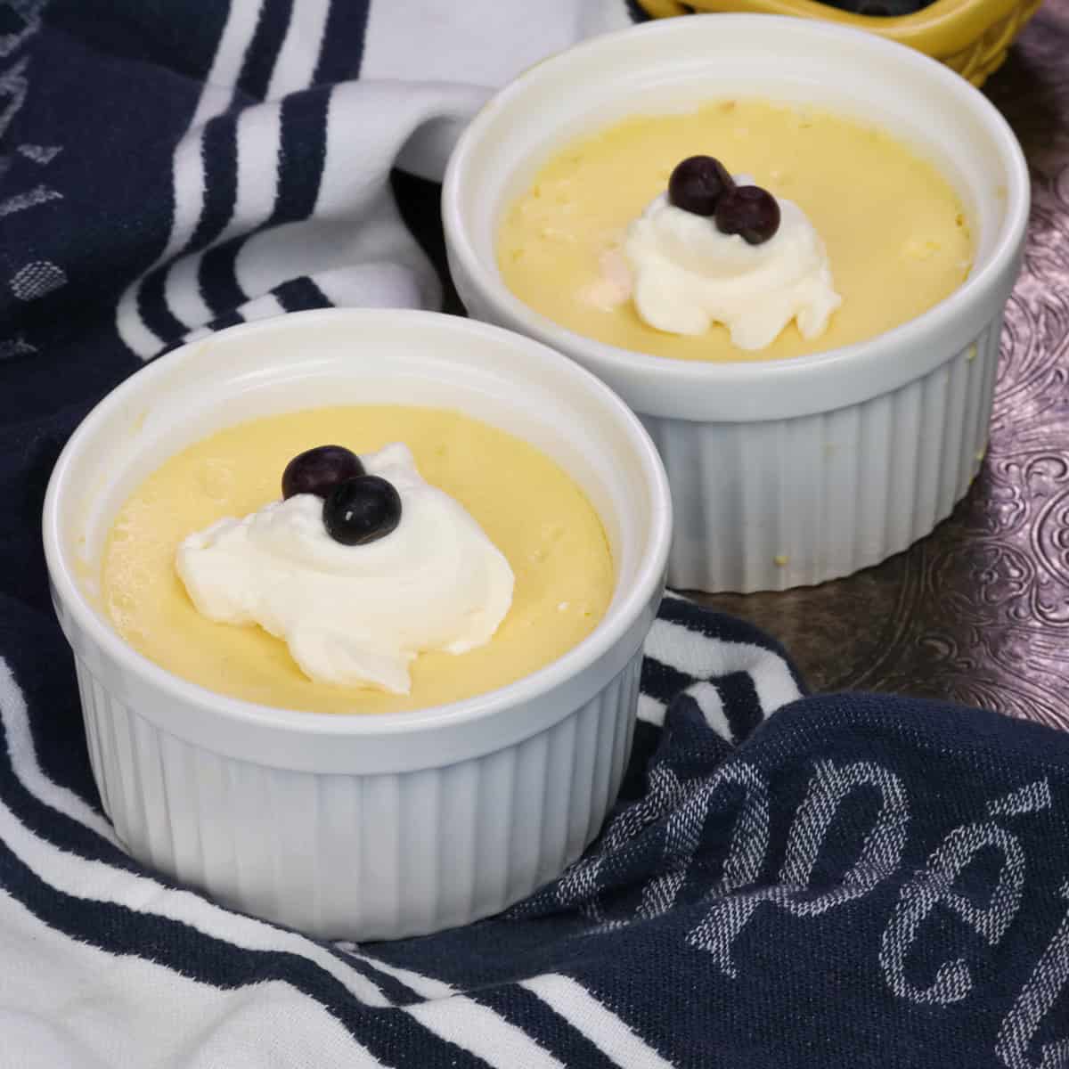 two ramekins on a silver tray filled with cheesecake.