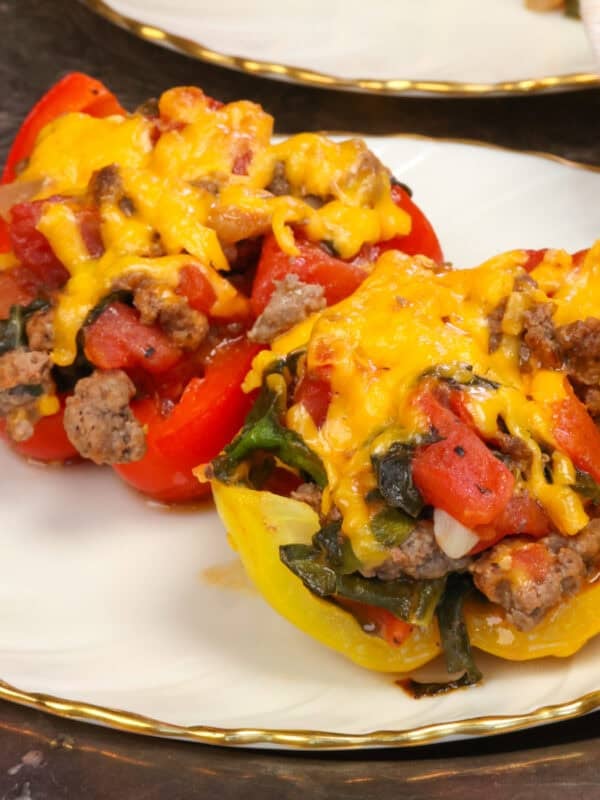 two stuffed pepper halves on two plates.