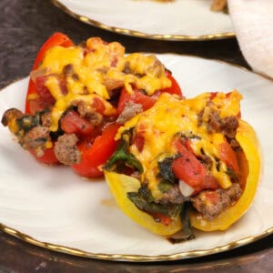 two stuffed peppers on a white plate.