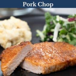 a slice pork chop on a plate with a fork on the side.