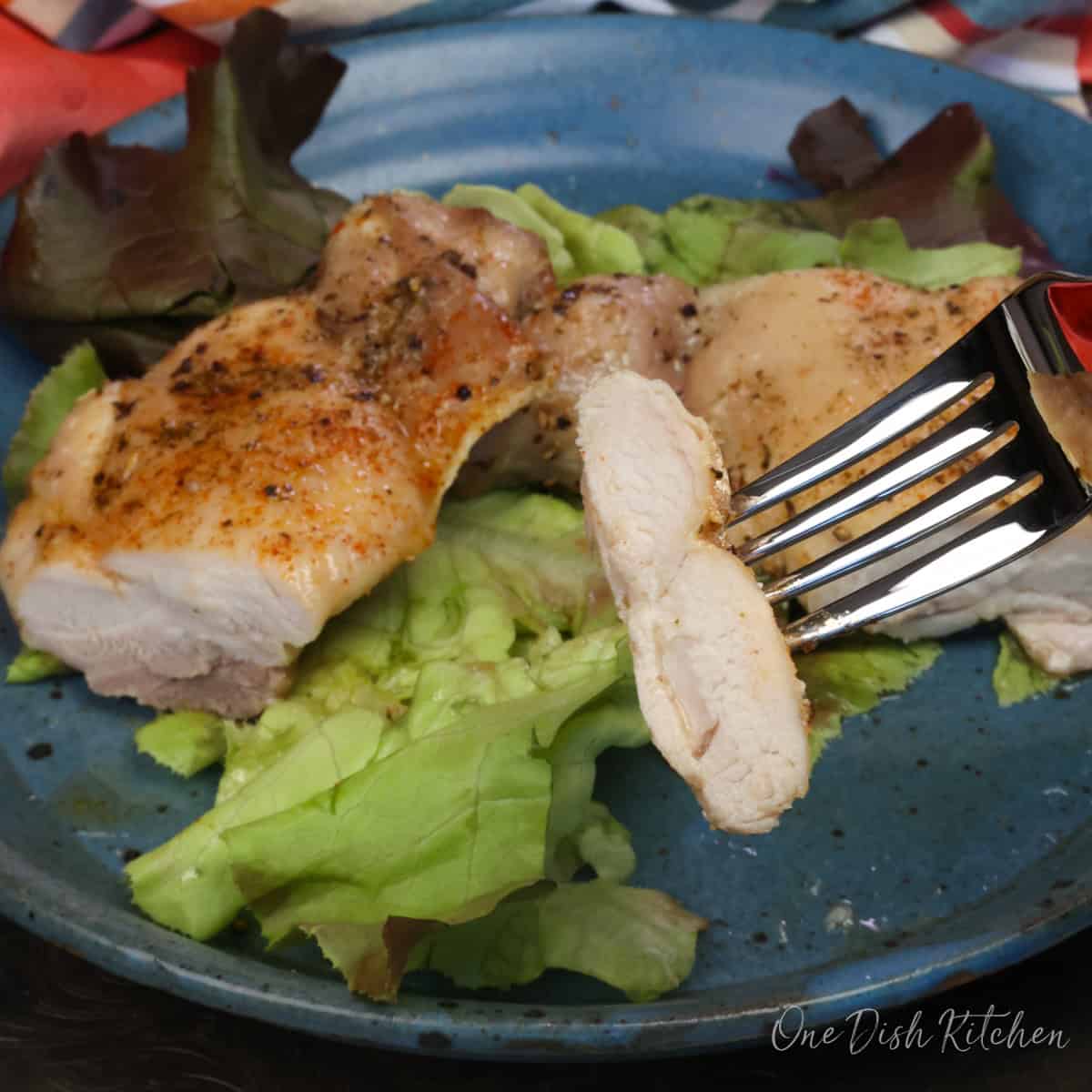 a sliced chicken thigh on a blue plate.