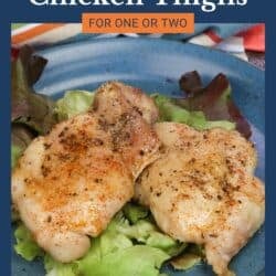 two baked chicken thighs on a plate.