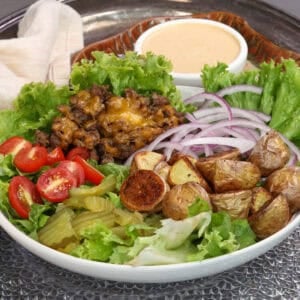 a hamburger bowl with burger sauce on the side.
