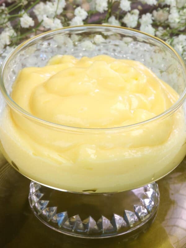 a single bowl of vanilla custard on a green plate.
