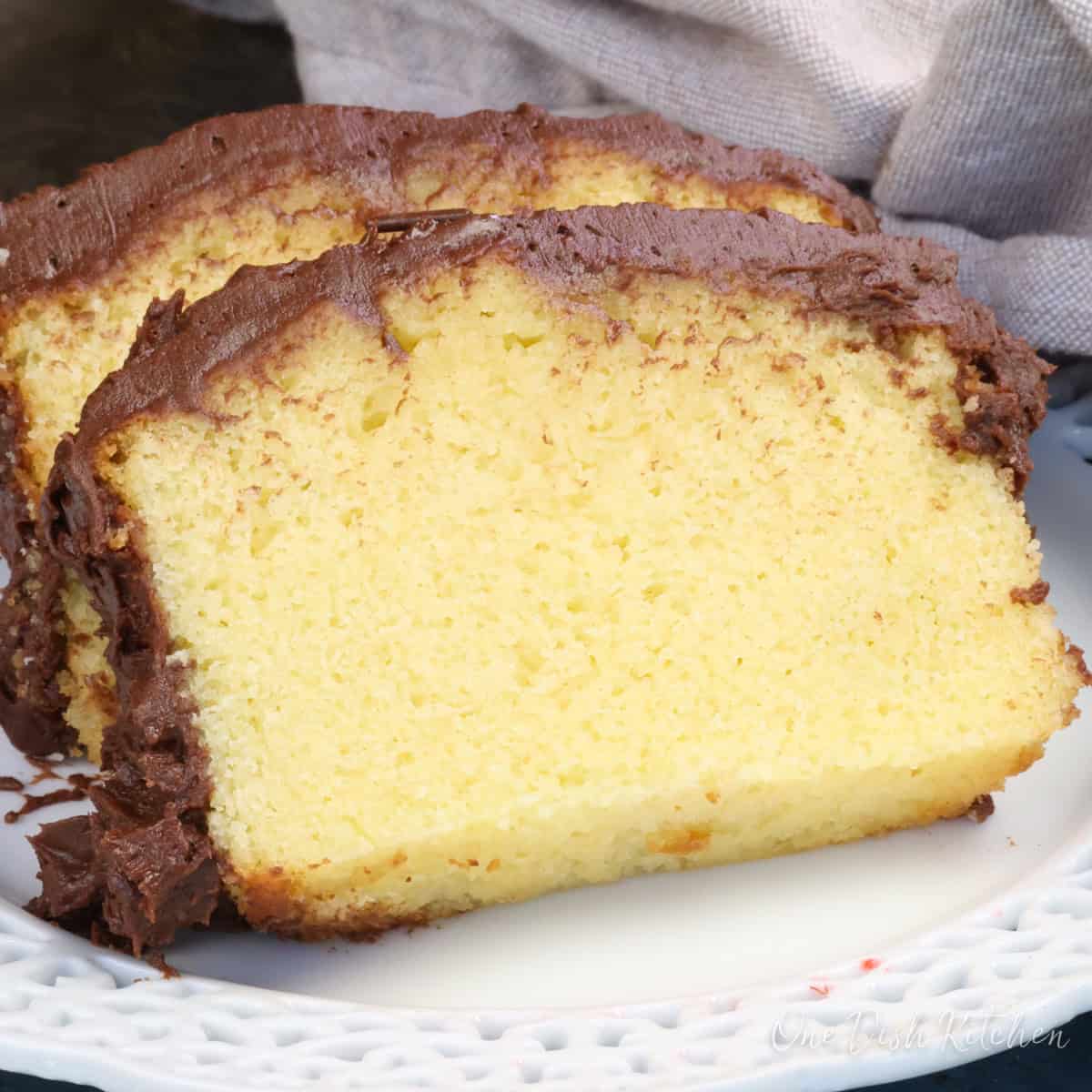 two slices of a yellow cake on a white plate.
