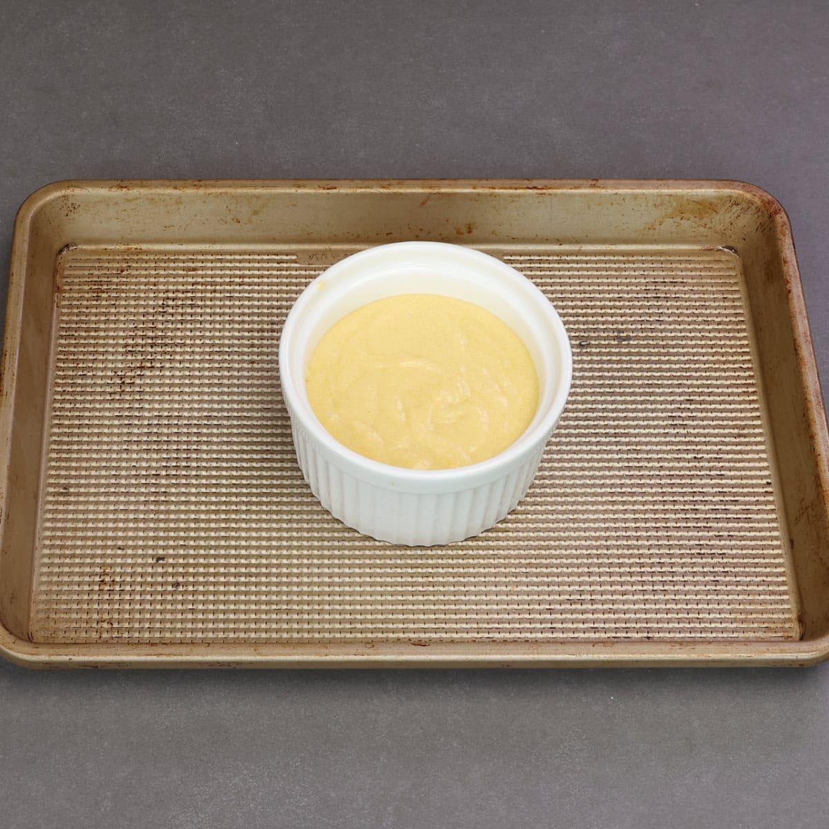 unbaked yellow cake batter in a white ramekin.