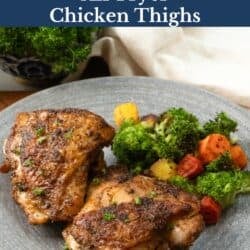 two chicken thighs on a gray plate.