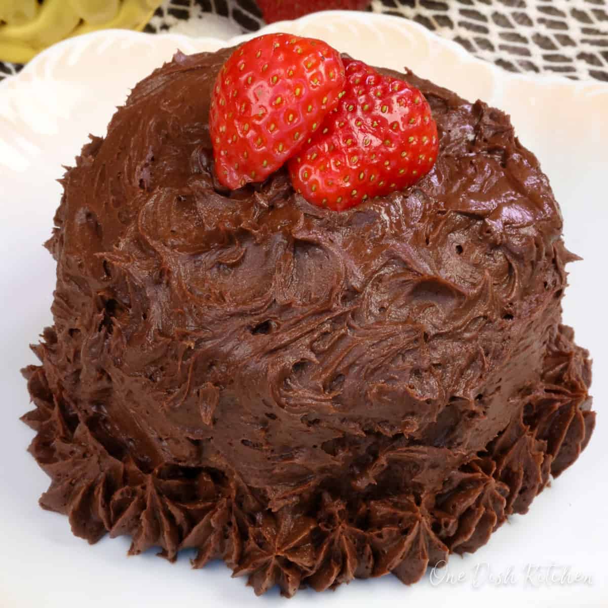 a small cake topped with chocolate buttercream frosting.