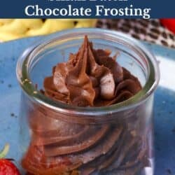 a small batch of chocolate frosting in a jar surrounded by fresh strawberries.
