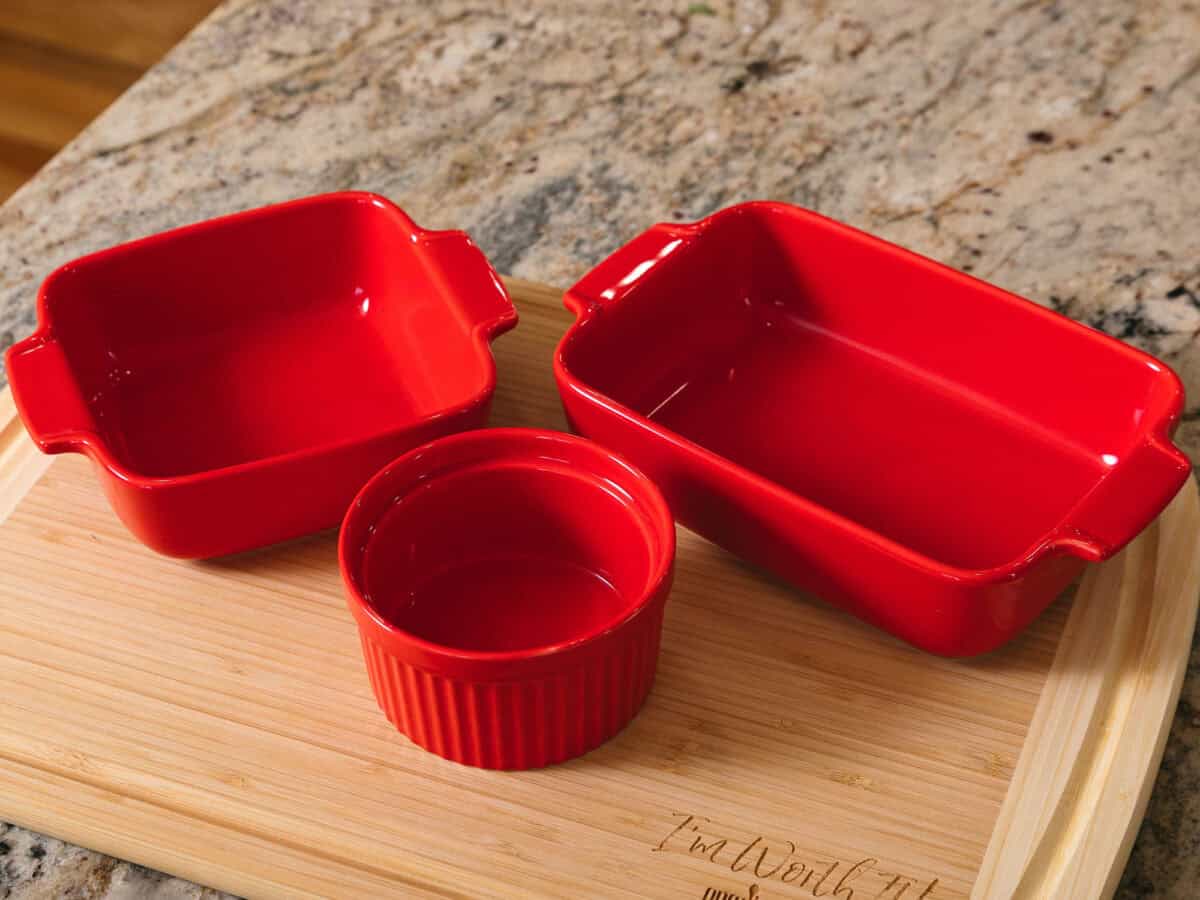 a red square, rectangle and ramekin on cutting board.