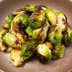 a small batch of air fryer brussels sprouts on a brown plate.