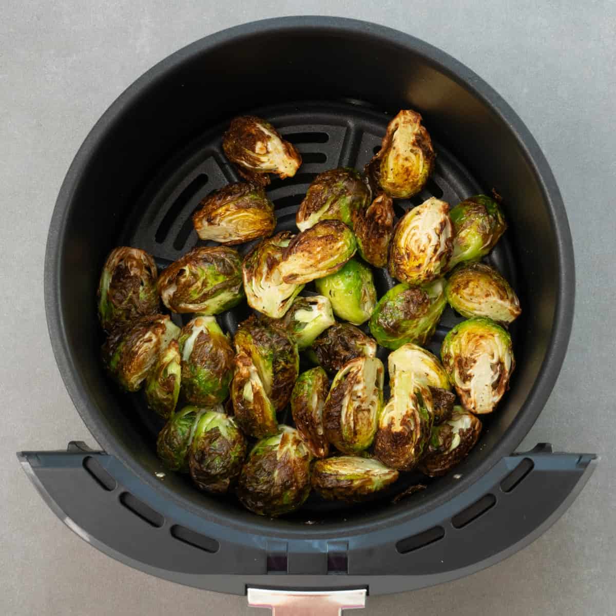 brussels sprouts in an air fryer basket.
