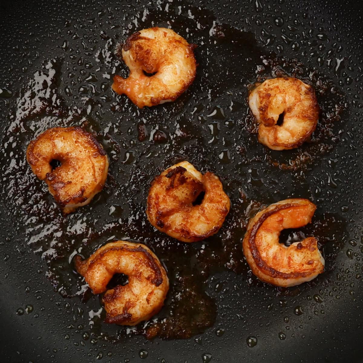 bang bang shrimp cooking in a skillet.