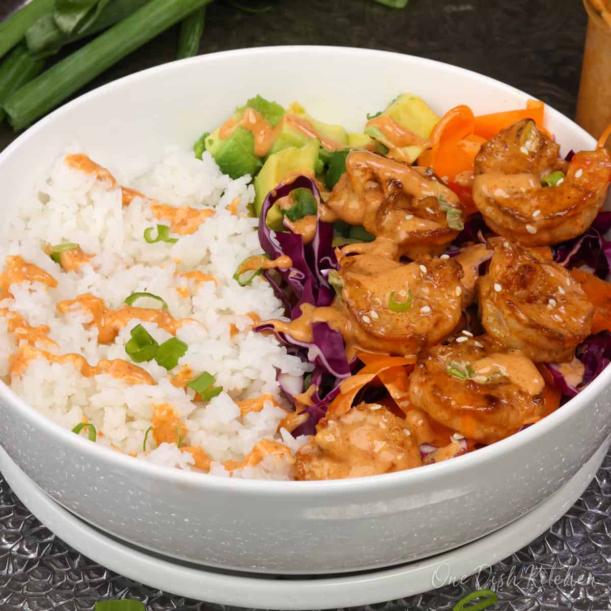 a rice bowl topped with bang bang shrimp.