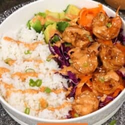 a shrimp rice bowl topped with bang bang sauce.