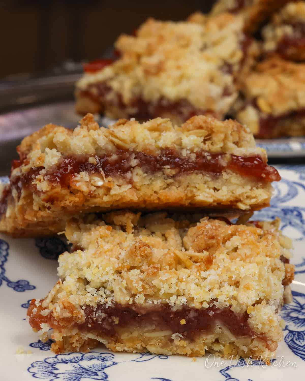 two jam-filled oatmeal bars on a blue plate.