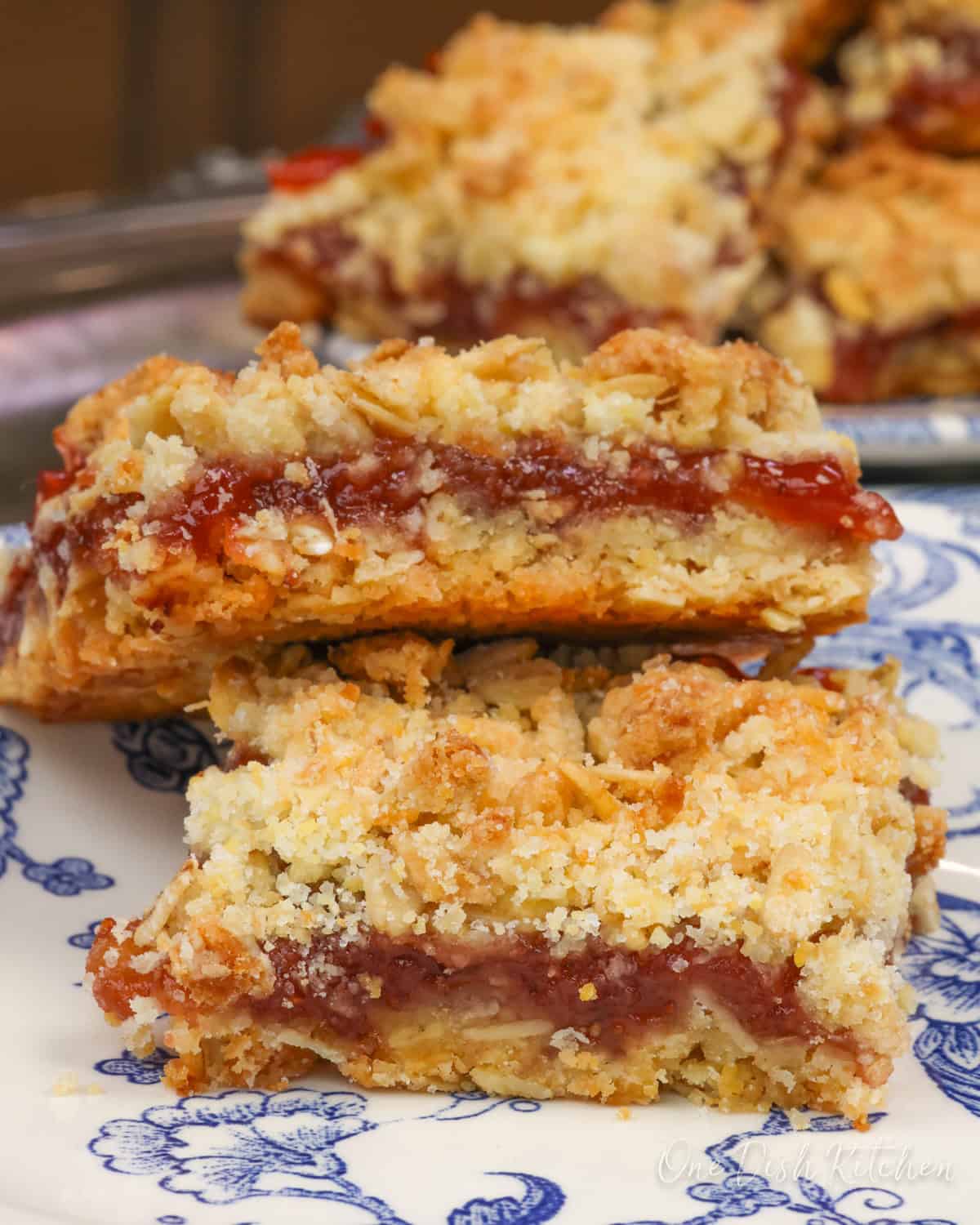 two jam-filled oatmeal bars on a blue plate.