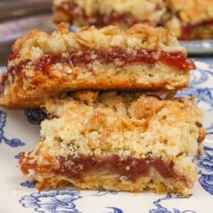 two jam-filled oatmeal bars on a blue plate.
