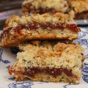 two jam-filled oatmeal bars on a blue plate.