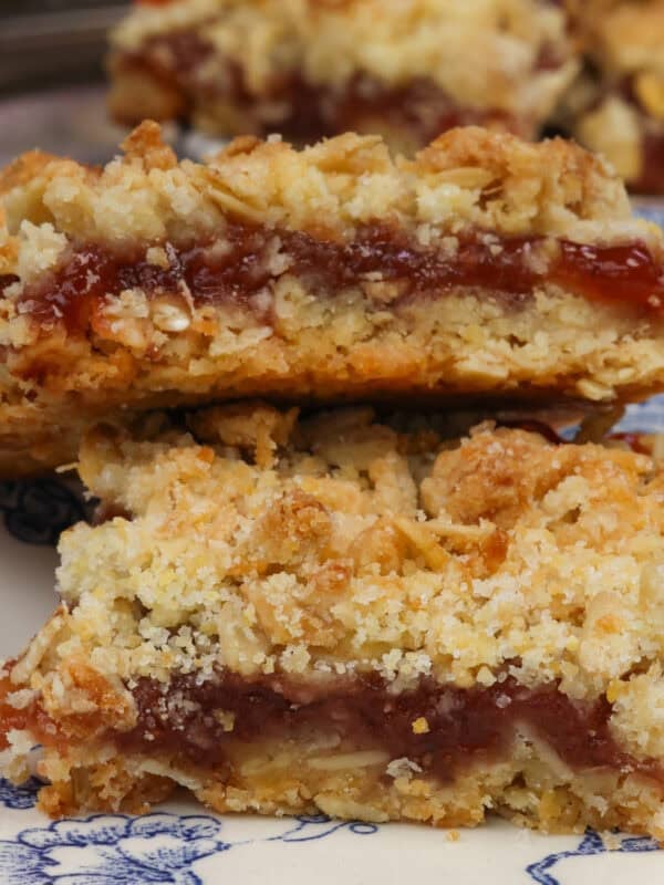 two jam-filled oatmeal bars on a blue plate.