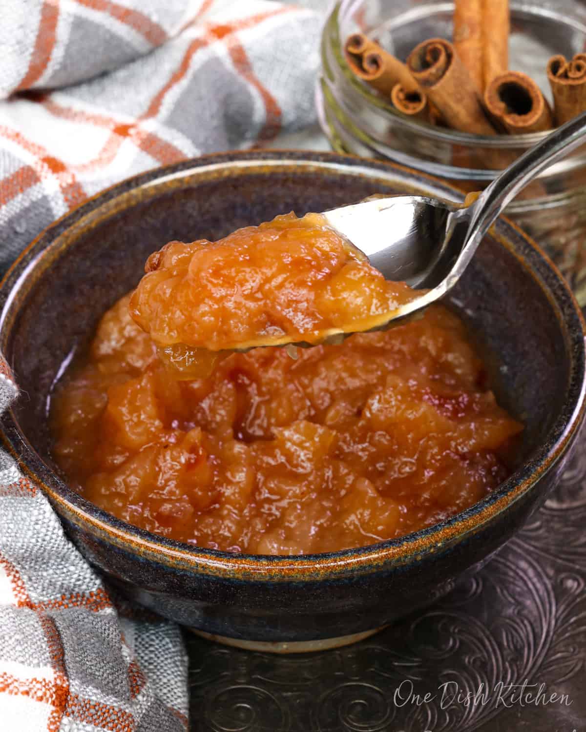 a single serving of homemade applesauce with spoon on the side of the bowl.