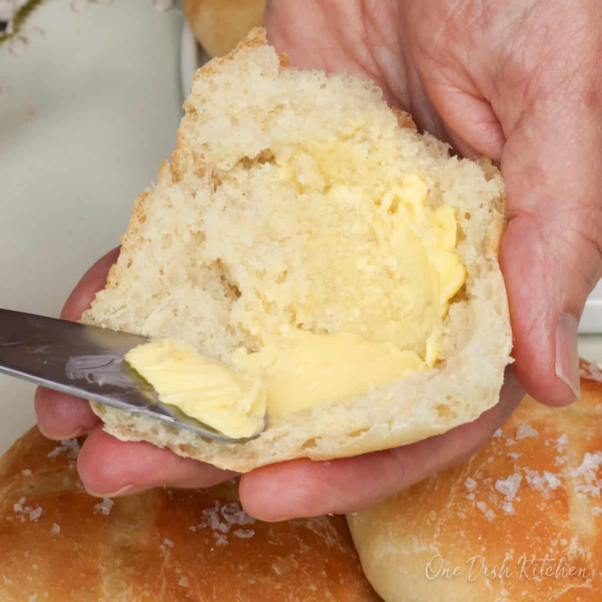 a french bread roll sliced in half and topped with butter.