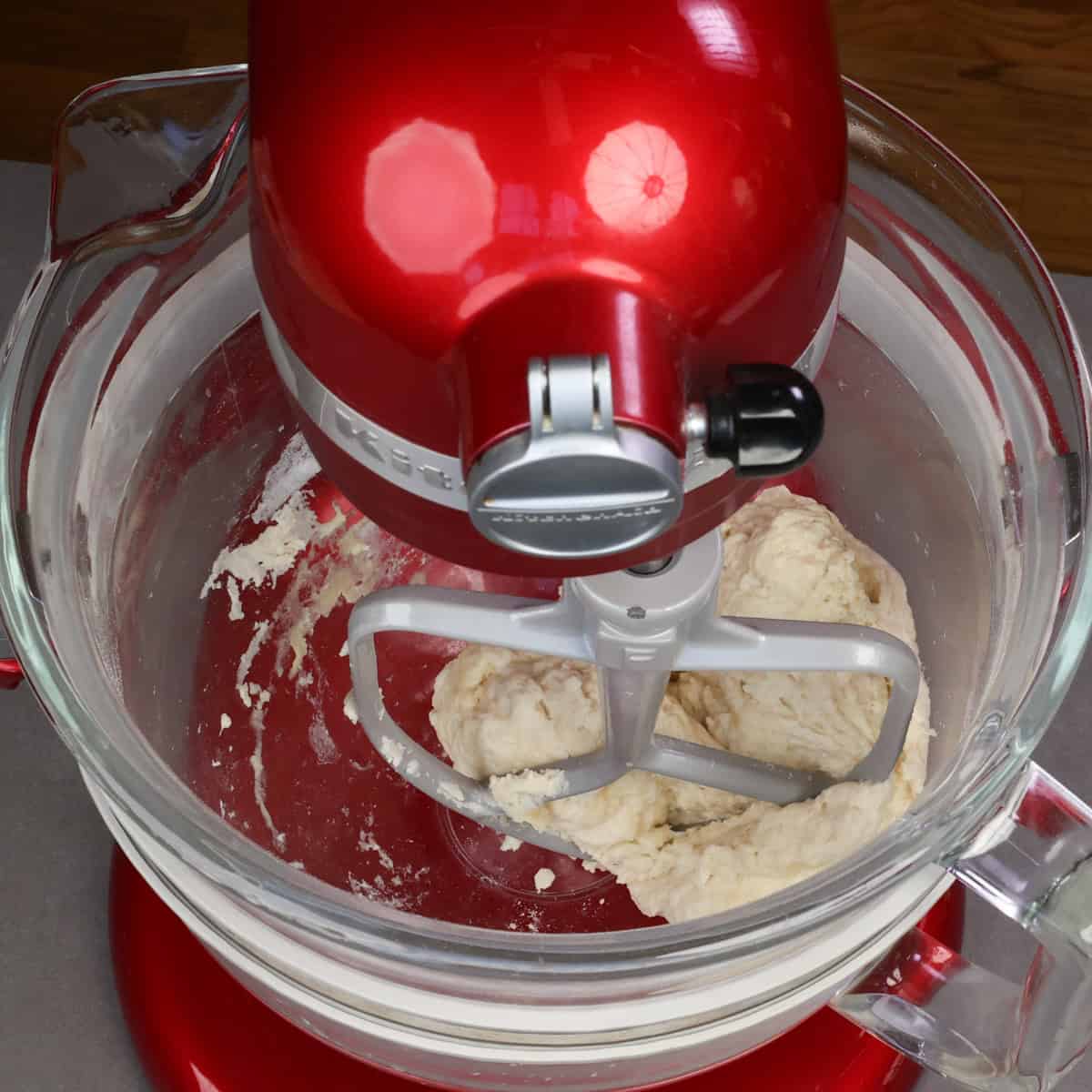 french bread dough coming together in a mixer with a paddle attachment.