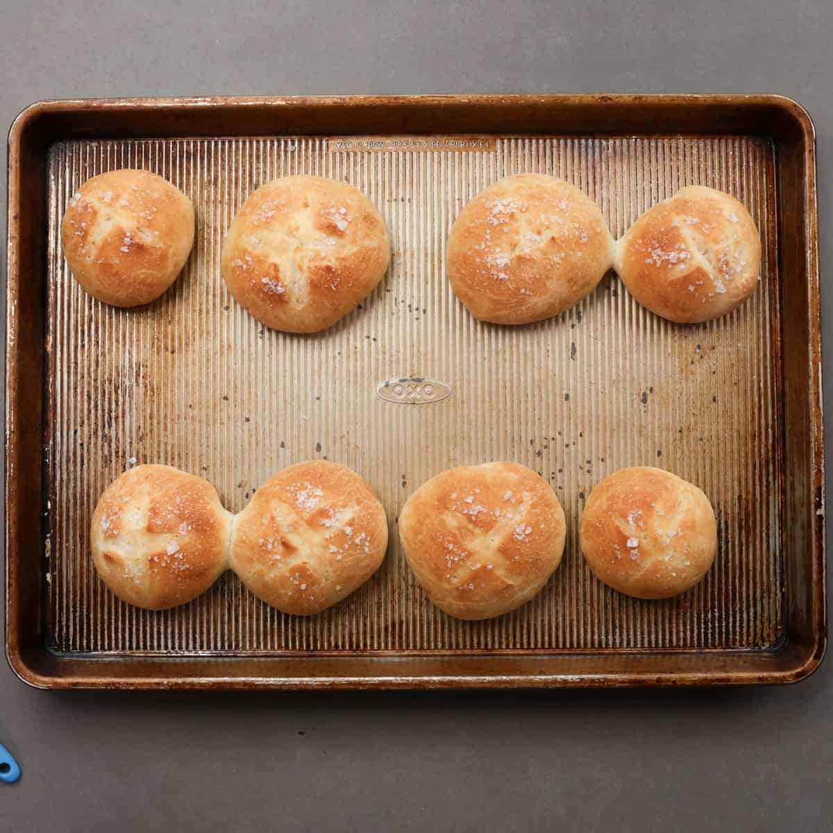 a small batch of french bread rolls on a baking sheet.