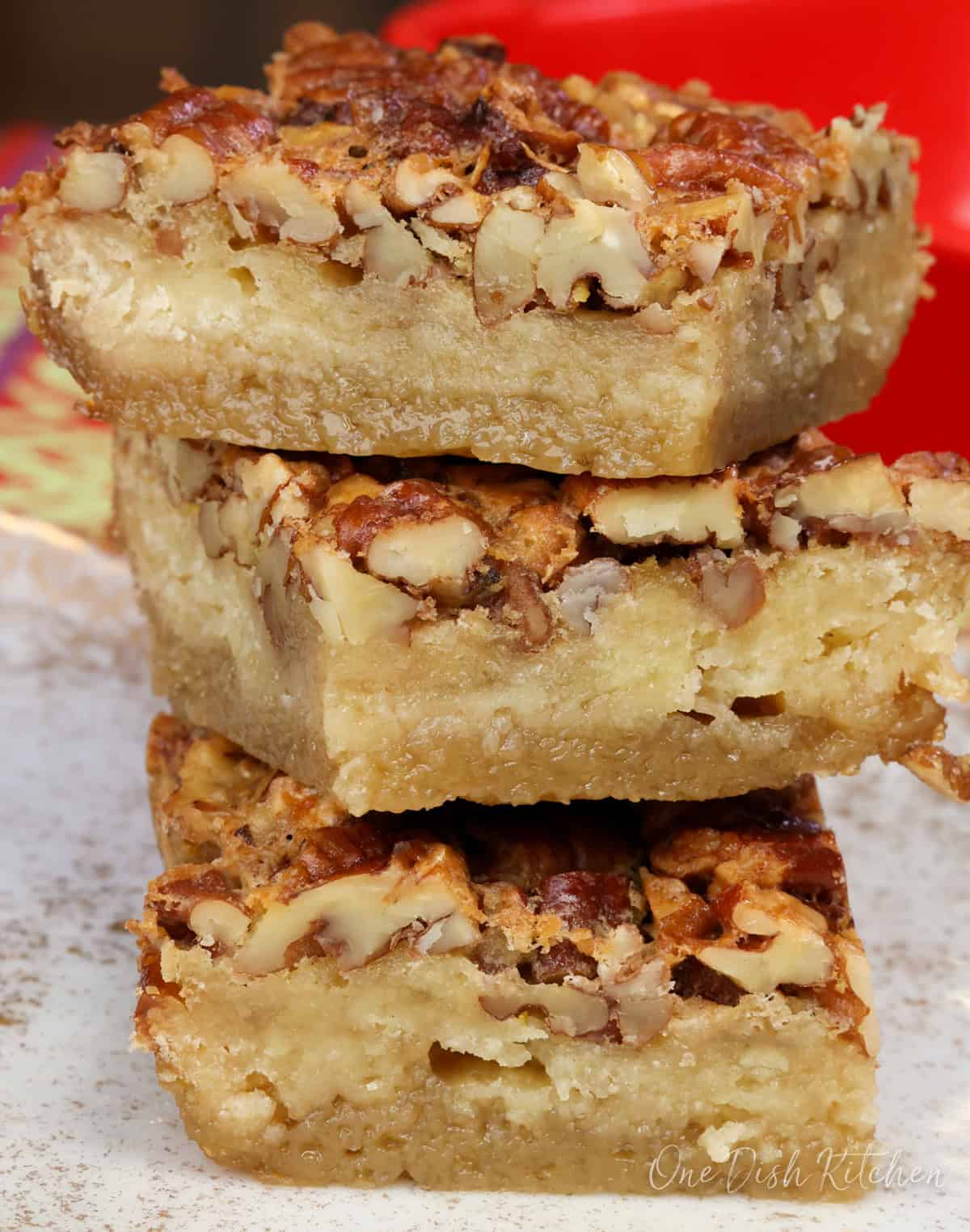 three maple pecan pie bars stacked on top of each other.