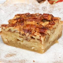 a single pecan pie bar on a white plate.