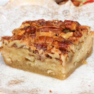 a single pecan pie bar on a white plate.
