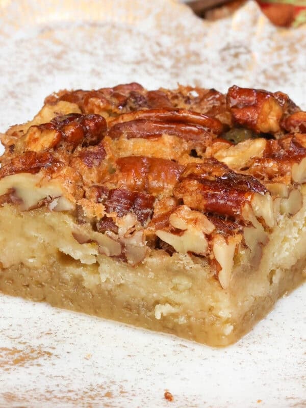 a single pecan pie bar on a white plate.