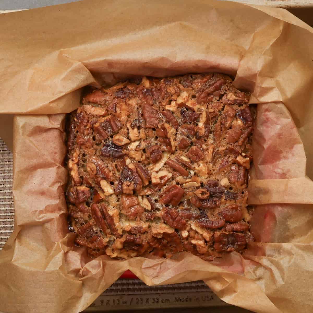 a small pecan pie without corn syrup in a red baking dish.