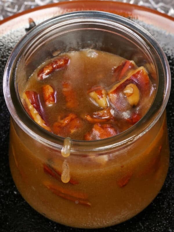 a small batch of homemade butter pecan syrup in a jar.