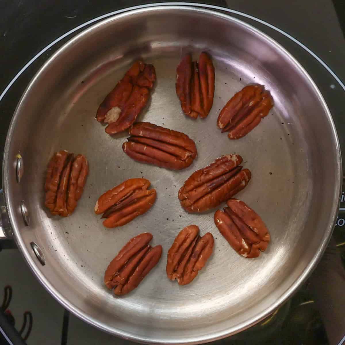 pecans toasting in a pan.
