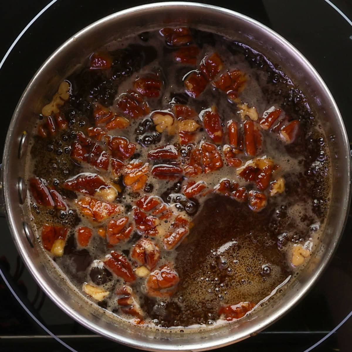 a small batch of butter pecan pancake syrup simmering in a small saucepan.