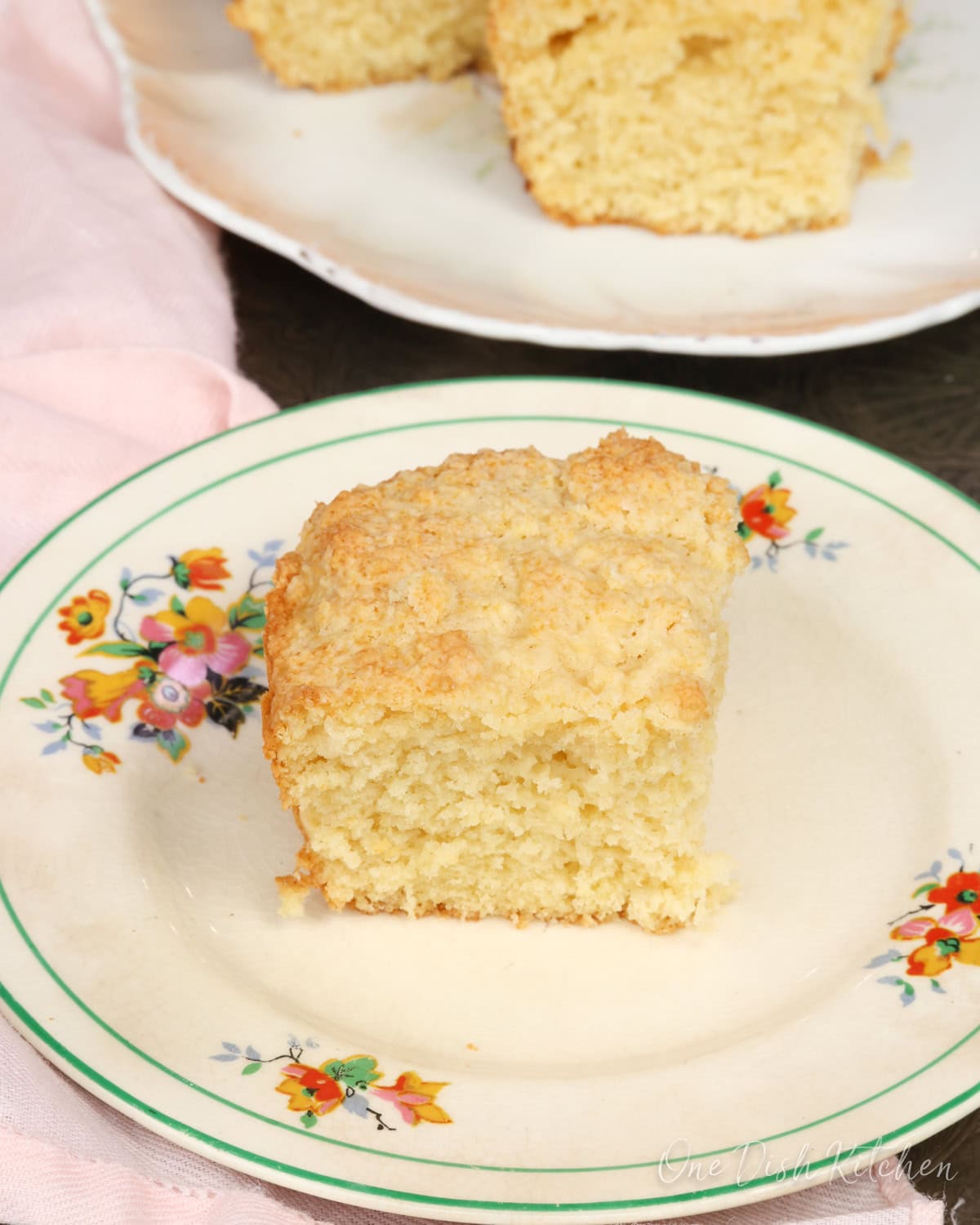 a slice of buttermilk bread on a white plate with the rest of the buttermilk loaf in a baking dish.