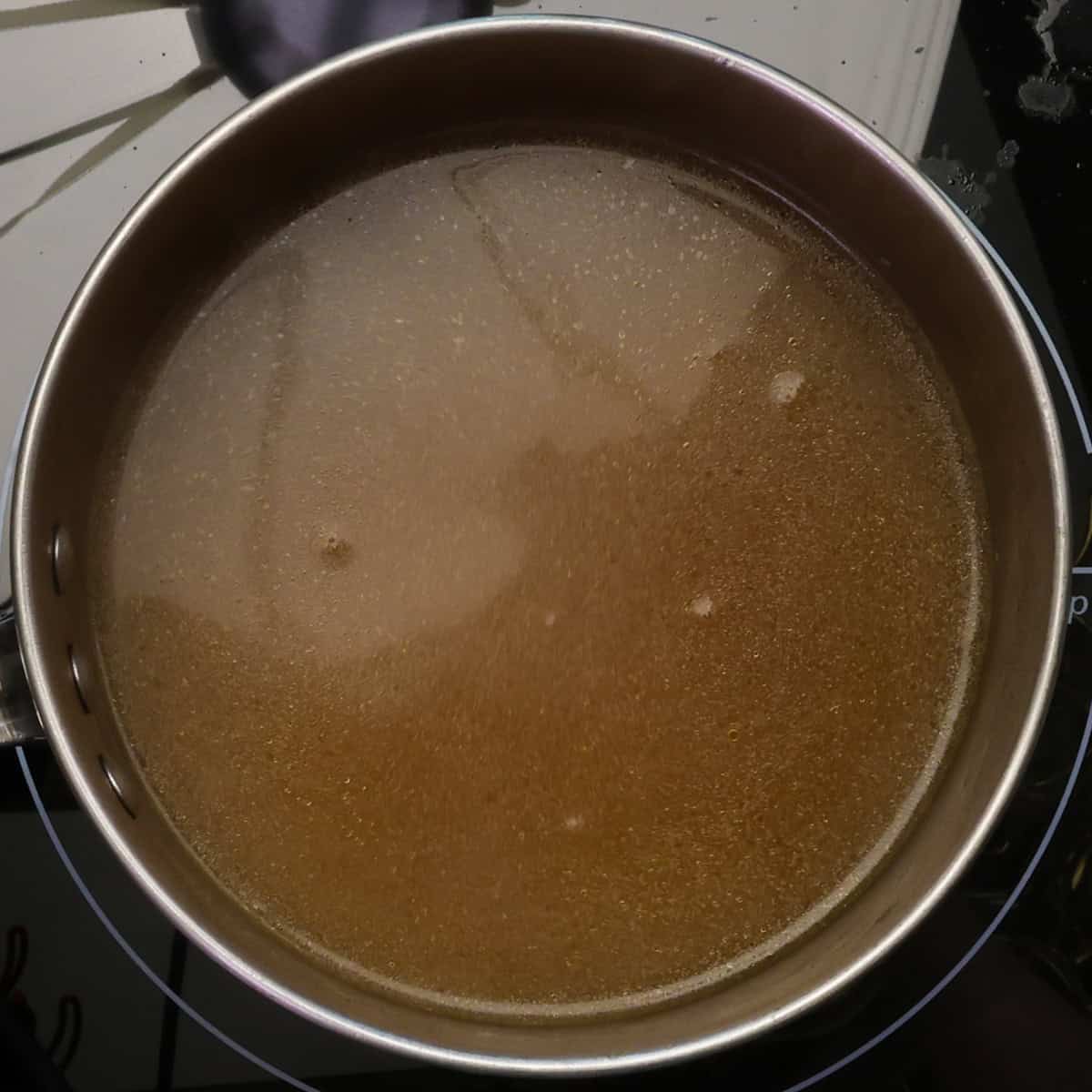 clear broth simmering in a saucepan.