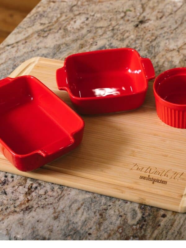 a red square, rectangle and ramekin on cutting board.