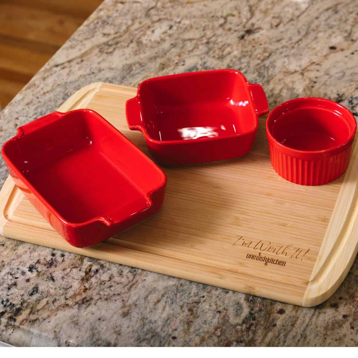 a red square, rectangle and ramekin on cutting board.