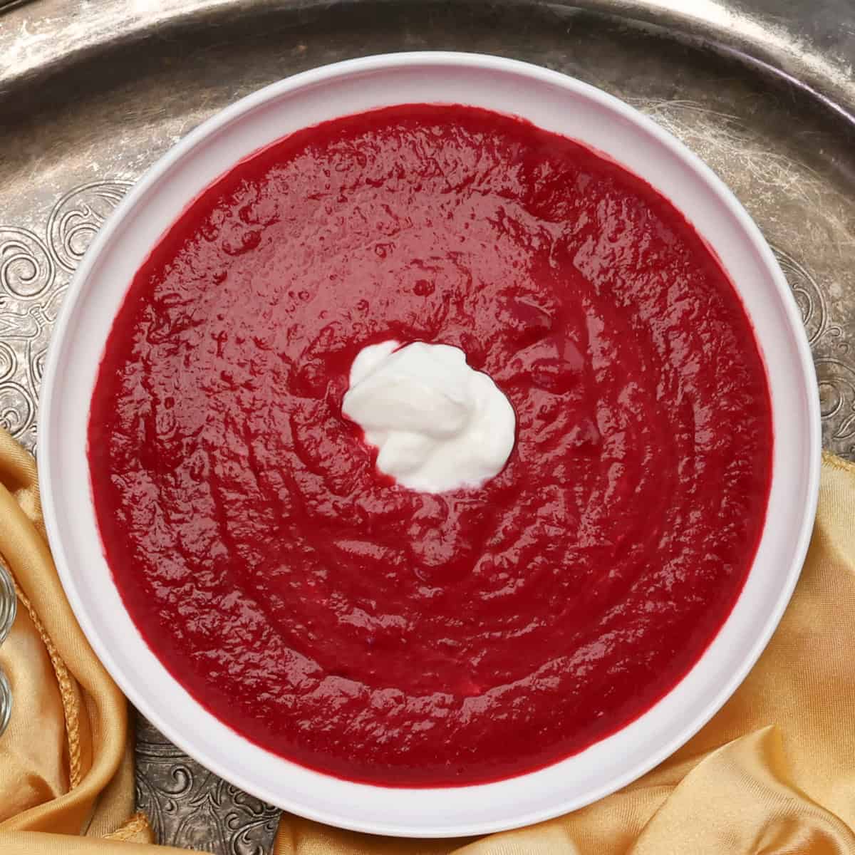 a bowl of borscht topped with sour cream.