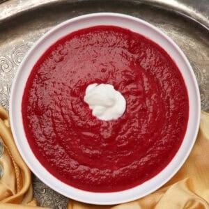 a bowl of borscht topped with sour cream.