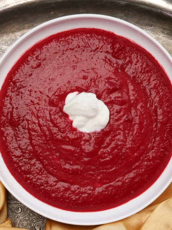 a bowl of borscht topped with sour cream.
